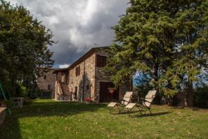 zwei Stühle vor einem Steingebäude in der Unterkunft Casale Pian di Fratta in Fabro