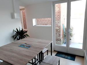 a dining room with a wooden table and a window at La Belle Aultoise, 4 chambres, WIFI, Vue mer, Baie de Somme in Ault