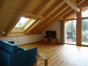 a living room with a blue couch and a tv at Ferienwohnung Seidlpark im Haus Ecker in Murnau am Staffelsee