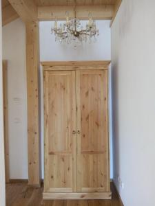 Cette chambre comprend un placard en bois et un lustre. dans l'établissement Ferienwohnung Seidlpark im Haus Ecker, à Murnau am Staffelsee