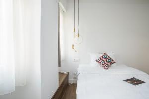 a white bedroom with a bed and a window at Bahar Boutique Hotel in Thessaloniki