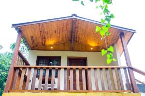 una casa con portico e tetto in legno di Chalés Luz da Montanha a Núcleo Mauá