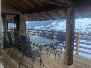 einen Tisch und Stühle auf dem Deck einer Hütte in der Unterkunft Grand appartement avec terrasse à Chez-Les-Reuses in Orsières