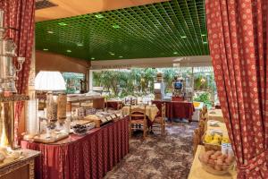 a restaurant with tables and chairs and a green ceiling at Hotel Venezia in Mestre