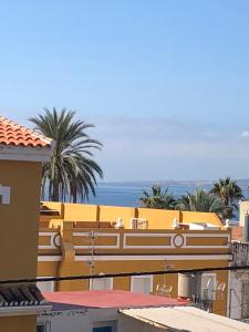 żółty budynek z widokiem na ocean w obiekcie Relaxing vacation at the beach w Maladze