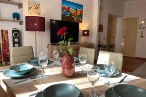 a table with plates and glasses and a vase on it at Casa Vacanze Antico Cassaro in Palermo