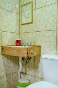 bagno con lavandino in legno e servizi igienici. di Chalés Luz da Montanha a Núcleo Mauá