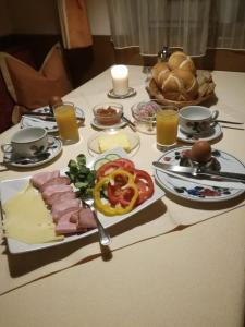 a table with cheese and meats and bread on it at Gästehaus Holaus in Mayrhofen