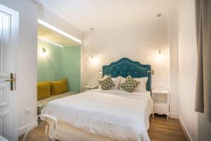 a bedroom with a large white bed with a blue headboard at Bahar Boutique Hotel in Thessaloniki