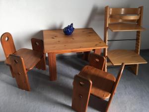 ein Holztisch und ein Stuhl mit einer blauen Vase darauf in der Unterkunft Komfortferienwohnung in ruhiger Lage mit 128qm in Grömitz in Grömitz