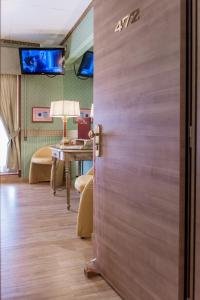 una porta in una stanza con tavolo e televisore di Hotel Venezia a Mestre