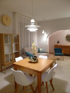 マリーナ・ディ・ピスティッチにあるLa Casa del Soleのリビングルーム(木製テーブル、白い椅子付)