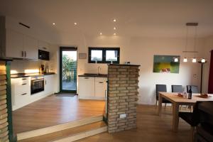 a kitchen and dining room with a brick fireplace at Ferienhaus Svala in Brodersby OT Schönhagen