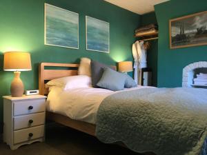 1 dormitorio con cama y pared verde en Bright Moments Holiday Home, en Beverley