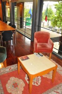 a living room filled with furniture and a red chair at Hotel Central Parque in Maia