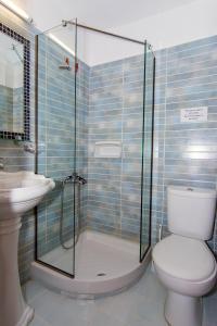 a bathroom with a shower and a toilet and a sink at Poseidon Apartments in Tolo