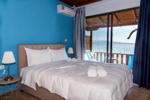 a bedroom with a bed with a view of the ocean at Poseidon Apartments in Tolo