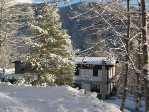 a building with a snow covered tree in front of it at Mansarda in montagna in Abetone