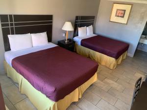 a hotel room with two beds and two lamps at Executive Inn & Suites Beeville in Beeville