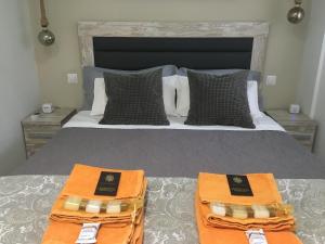 a bedroom with a bed with two orange towels on it at MMBB Boutique Apartment in Marbella