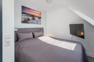 Schlafzimmer mit einem Bett und einem Flachbild-TV in der Unterkunft Ostseemeerblick in Schönberger Strand