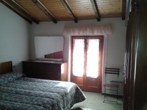 a bedroom with a bed and a dresser and a window at Mansarda in montagna in Abetone