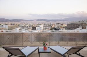 a patio area with a table and chairs at My Athens Hotel in Athens