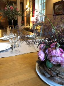 une table avec une plaque de fleurs sur une table dans l'établissement Domaine du Vertbois, à La Haye-du-Theil