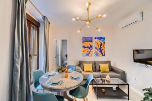 a living room with a table and chairs and a couch at Apartamentos San Pedro in Seville