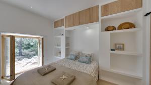 een slaapkamer met een bed met kussens erop bij Feliz Lagartija in Cala Saona