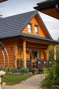 ein Holzhaus mit einer Veranda und einem Balkon in der Unterkunft Chaty Anety Domki Całoroczne in Solina