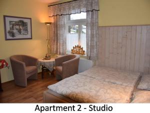 a bedroom with a bed and two chairs and a window at Ferienwohnung Werner in Annaberg-Buchholz