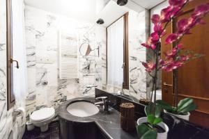 een badkamer met een wastafel, een toilet en een spiegel bij Rialto Dream - Wifi in Venetië