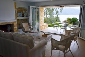 a living room with a couch and a table and chairs at Skorponeria beachfront house in Skroponeria