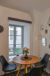 d'une salle à manger avec une table, des chaises et une fenêtre. dans l'établissement COSY APPARTEMENT EN PLEIN CENTRE-VILLE !!!, à Avignon