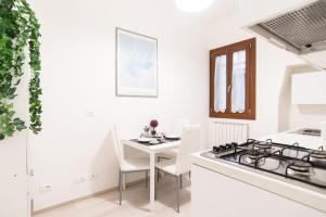 a white kitchen with a table and a stove at Lovely in San Marco in Venice