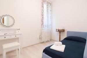 a white bedroom with a blue bed and a mirror at Lovely in San Marco in Venice