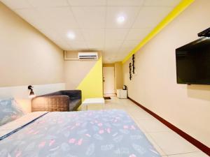 um quarto com uma cama e uma televisão de ecrã plano em Wei Yang Guest House em Yongkang