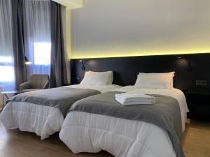 a hotel room with two beds with white sheets at Apartamento céntrico Logroño Confort con Aire Acondicionado in Logroño