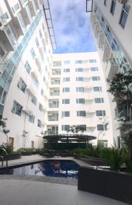 ein großes weißes Gebäude mit einem Pool davor in der Unterkunft One Madison Place, Tower 2 - 10N MEGAWORLD Iloilo in Iloilo City