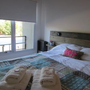 a bedroom with a bed with two towels on it at Duplex Minimalista in Esquel