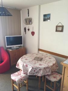 een kleine kamer met een tafel en een televisie bij Orcieres joli studio in Orcières