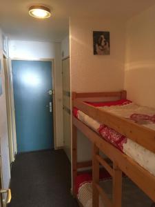een kamer met 2 stapelbedden en een blauwe deur bij Orcieres joli studio in Orcières