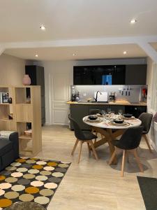 cocina y sala de estar con mesa y sillas en Le Petit Remballais, en Avessac
