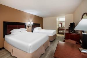 Un pat sau paturi într-o cameră la Days Inn & Suites by Wyndham Tyler