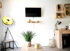 a living room with a flat screen tv on a wall at Futurostudio - Appart Hôtel Futuroscope - Poitiers in Jaunay-Clan