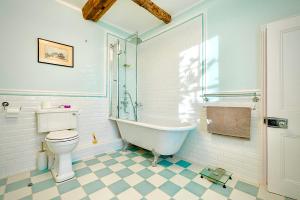 a bathroom with a tub and a toilet and a sink at Swafield Hall in Swafield