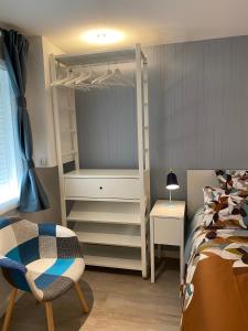 - une chambre avec des lits superposés blancs et une chaise dans l'établissement Le Petit Remballais, à Avessac