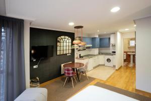a living room and kitchen with a table and a couch at DE LA GUARDIA LOFT ROSAL in Oviedo