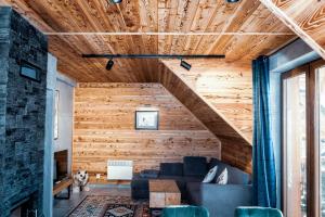 a living room with a couch and a wooden wall at Bury Miś in Jaworki